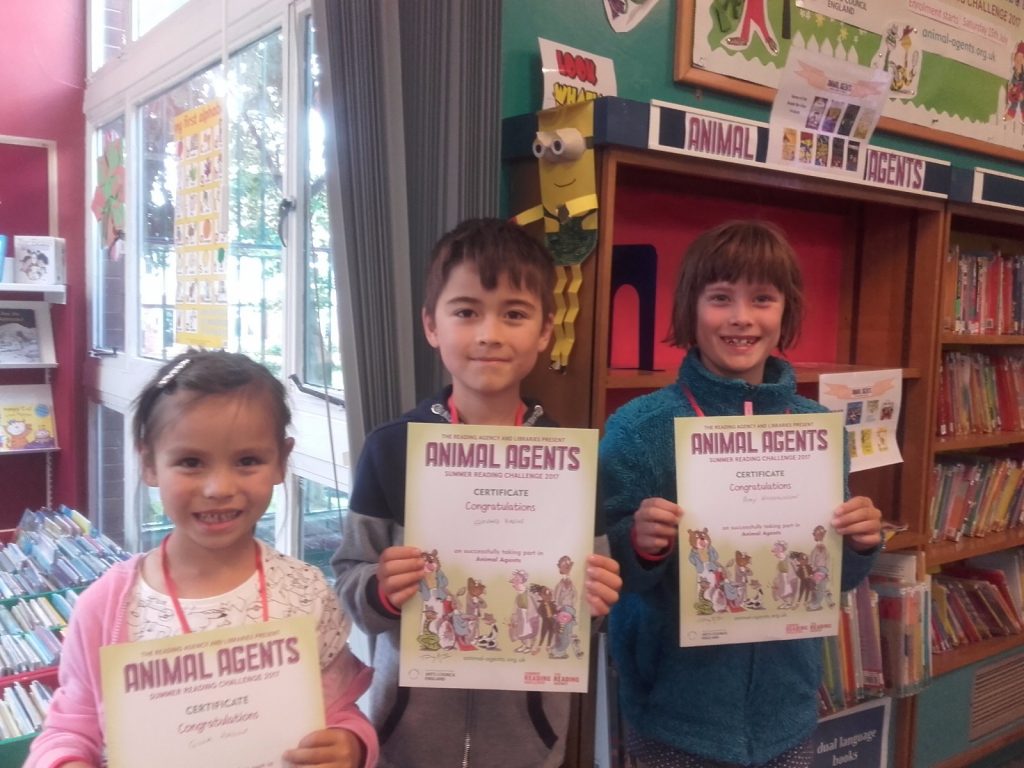 Photograph of three children collecting certificates.